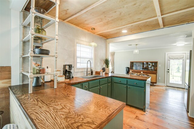 kitchen featuring hanging light fixtures, sink, light wood-type flooring, and green cabinetry