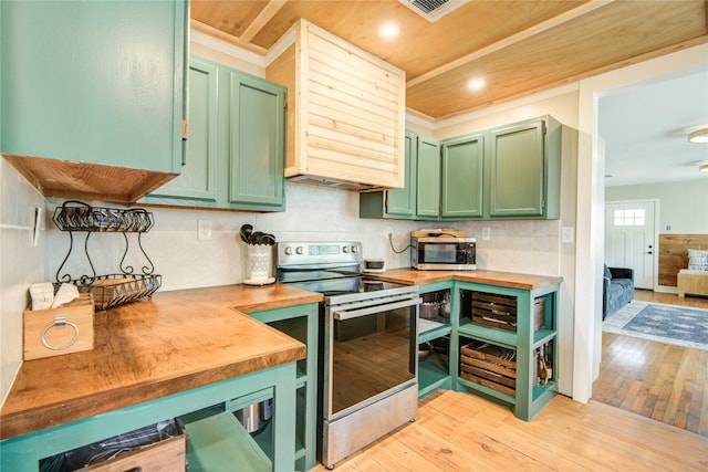 kitchen with butcher block countertops, green cabinets, light hardwood / wood-style floors, and appliances with stainless steel finishes