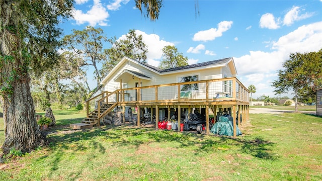 rear view of house with a deck and a yard