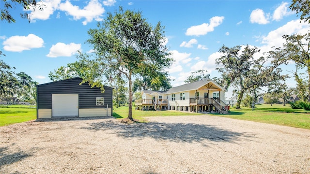 view of front of property with a front yard, a garage, an outdoor structure, and a deck