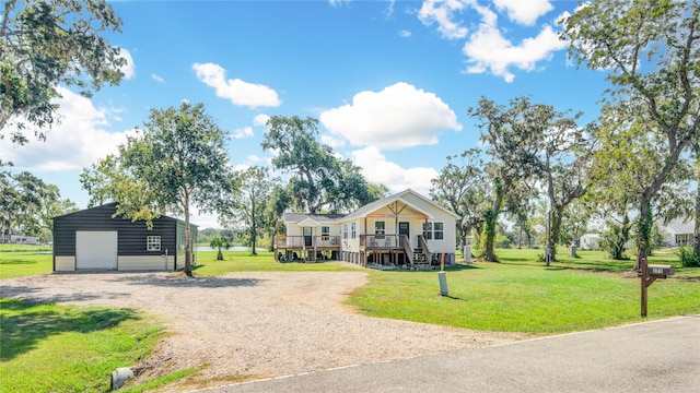 view of front of home featuring a garage, an outdoor structure, and a front yard