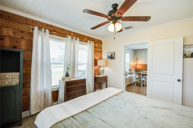 bedroom featuring ceiling fan, crown molding, and wood walls