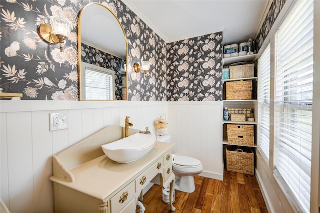 bathroom featuring hardwood / wood-style flooring, vanity, toilet, and crown molding