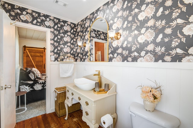 bathroom featuring hardwood / wood-style flooring, vanity, toilet, and crown molding