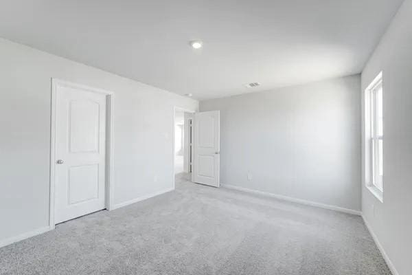 unfurnished room featuring light carpet