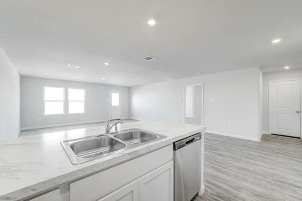 kitchen with stainless steel dishwasher, light hardwood / wood-style floors, white cabinetry, and sink