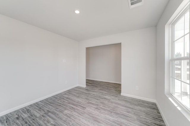 spare room with a wealth of natural light and light hardwood / wood-style floors