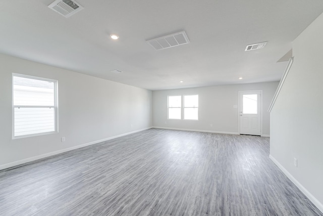 spare room with wood-type flooring and a healthy amount of sunlight