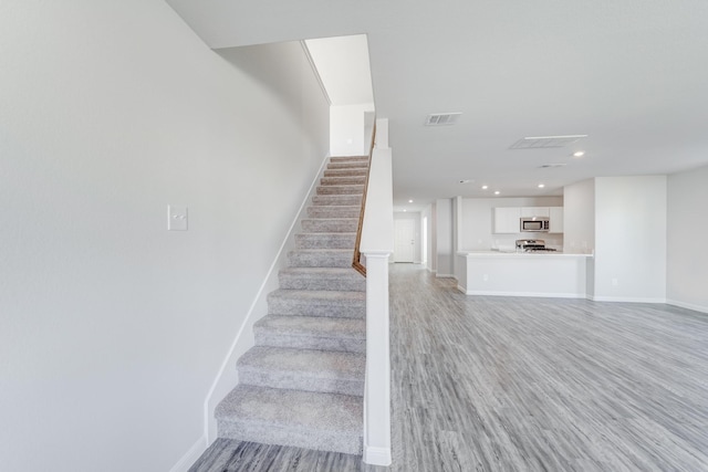 stairway with hardwood / wood-style floors