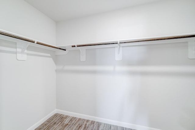 walk in closet with light hardwood / wood-style floors