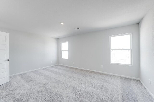 unfurnished room featuring light carpet