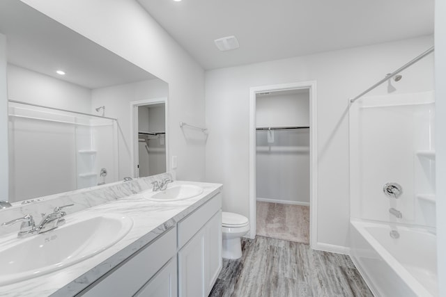 full bathroom featuring wood-type flooring, vanity, toilet, and  shower combination