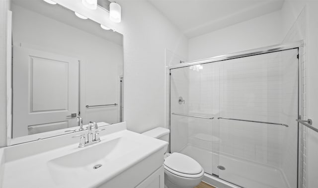 bathroom featuring vanity, toilet, and walk in shower