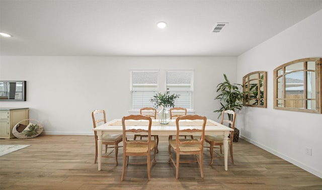 dining space featuring baseboards, visible vents, and wood finished floors