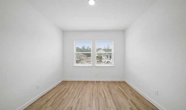 empty room featuring light wood-style flooring and baseboards