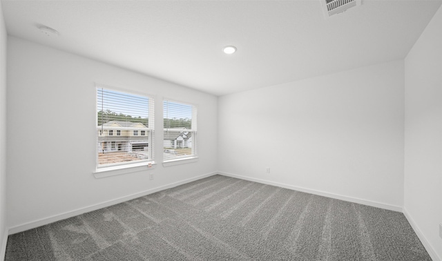 carpeted spare room featuring recessed lighting, visible vents, and baseboards