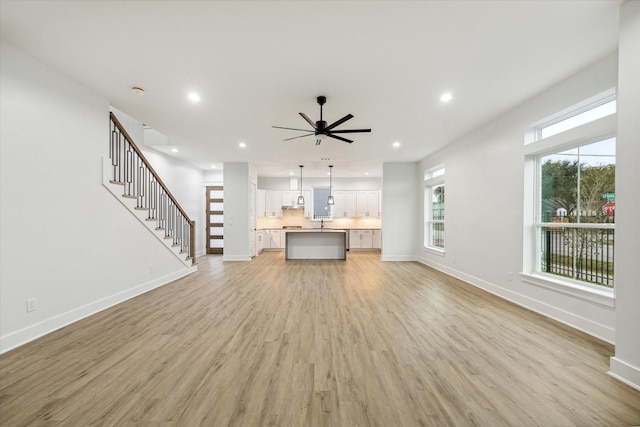 unfurnished living room with ceiling fan and light hardwood / wood-style floors