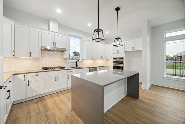 kitchen featuring a healthy amount of sunlight, white cabinetry, and a kitchen island