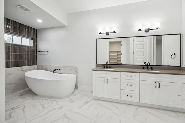 bathroom featuring vanity, tile walls, and a bathing tub