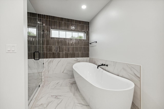 bathroom with separate shower and tub and tile walls