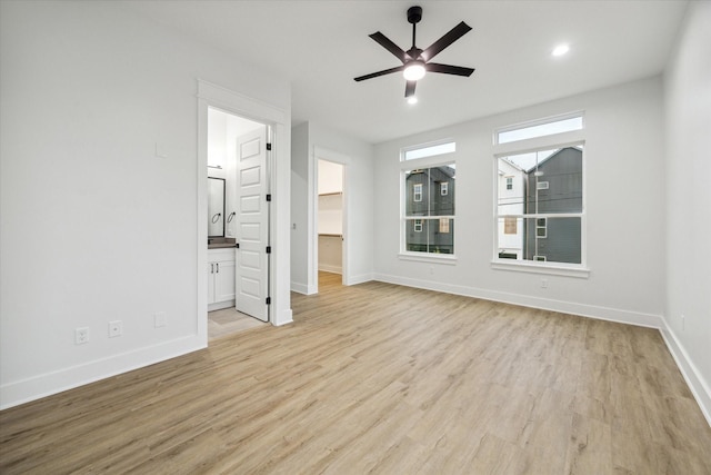 unfurnished bedroom featuring ensuite bathroom, light hardwood / wood-style flooring, and ceiling fan