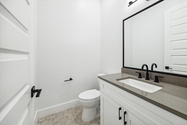 bathroom with tile patterned flooring, vanity, and toilet