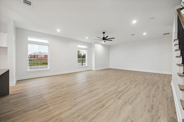 unfurnished living room with ceiling fan, light hardwood / wood-style flooring, and a healthy amount of sunlight