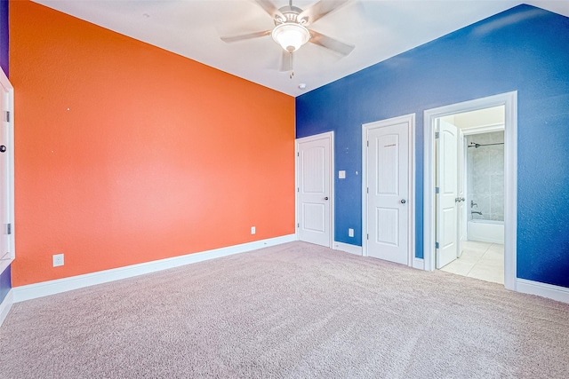 unfurnished bedroom with light carpet, ensuite bathroom, and ceiling fan