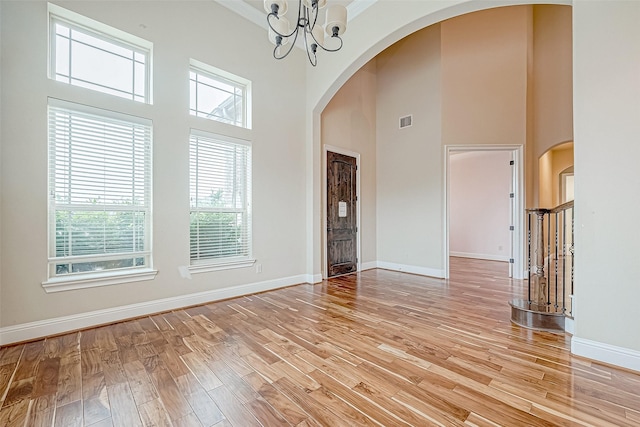 interior space featuring a wealth of natural light, light hardwood / wood-style flooring, and a towering ceiling