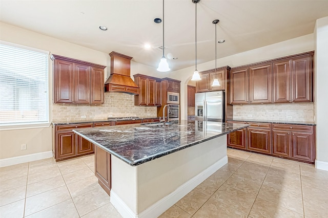 kitchen featuring sink, stainless steel appliances, an island with sink, pendant lighting, and custom range hood