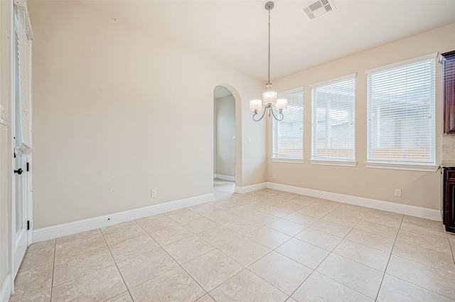 unfurnished dining area with a chandelier and light tile patterned flooring