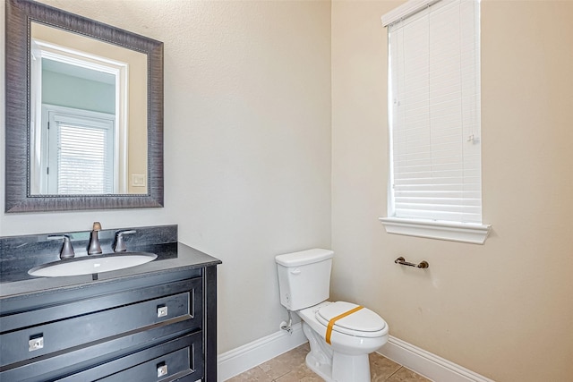 bathroom with tile patterned flooring, vanity, and toilet