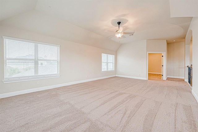 empty room featuring ceiling fan, light carpet, and vaulted ceiling