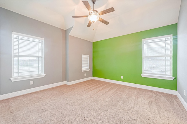 carpeted spare room featuring ceiling fan and vaulted ceiling