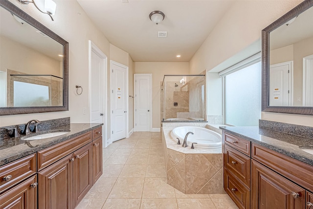 bathroom with tile patterned floors, vanity, and shower with separate bathtub