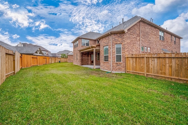 rear view of house with a yard and a patio