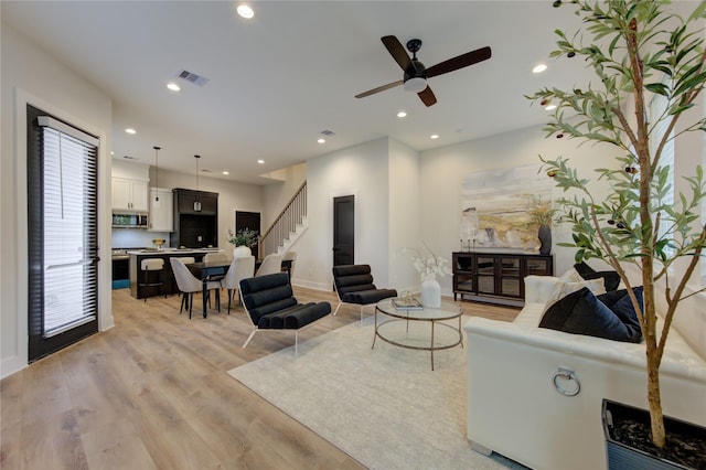 living room featuring ceiling fan and light hardwood / wood-style floors