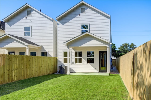 back of property with a lawn and cooling unit