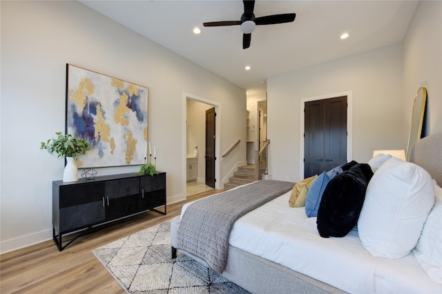 bedroom featuring a closet, connected bathroom, ceiling fan, and light hardwood / wood-style flooring