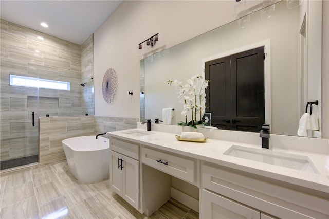 bathroom featuring vanity, tile walls, and shower with separate bathtub