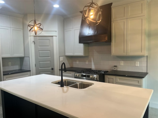 kitchen featuring stainless steel range with gas cooktop, sink, pendant lighting, and extractor fan