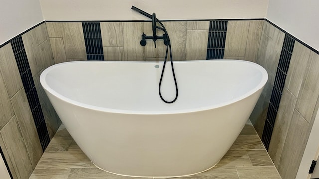 bathroom featuring a bathing tub and tile walls