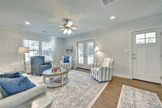 living room with a healthy amount of sunlight, dark wood-type flooring, and french doors