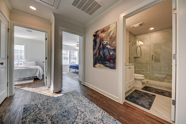 corridor with ornamental molding, wood finished floors, baseboards, and recessed lighting