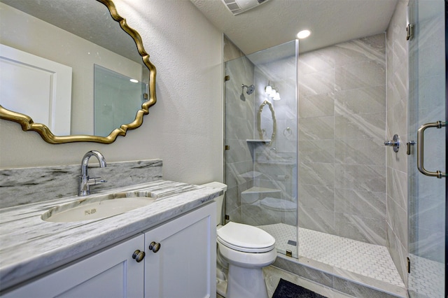 bathroom with vanity, toilet, an enclosed shower, and a textured ceiling