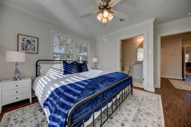 bedroom with hardwood / wood-style floors, ceiling fan, ornamental molding, and connected bathroom