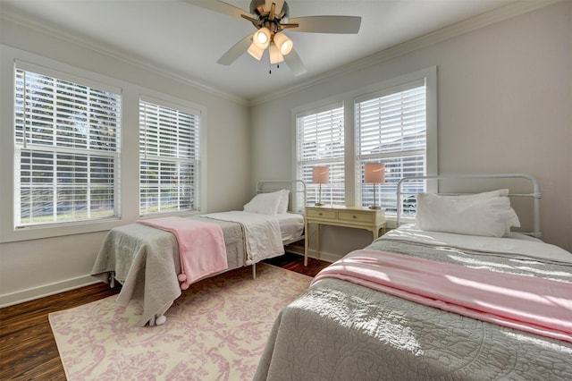 bedroom featuring wood finished floors, baseboards, crown molding, and ceiling fan