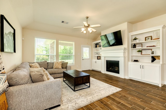 living room with a healthy amount of sunlight, ceiling fan, dark wood-type flooring, and lofted ceiling