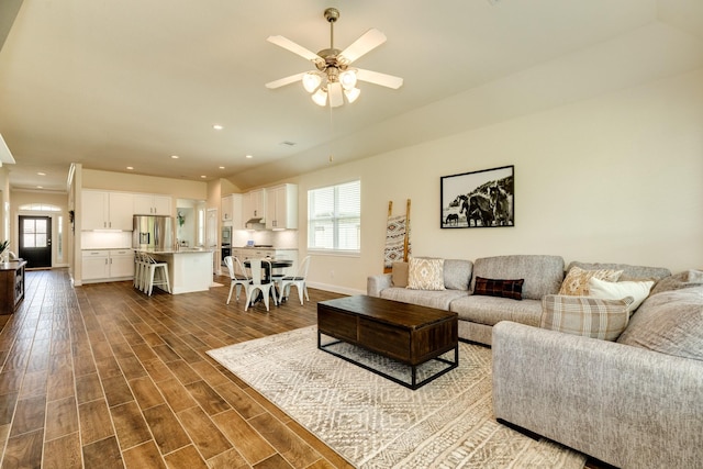 living room with dark hardwood / wood-style flooring and ceiling fan