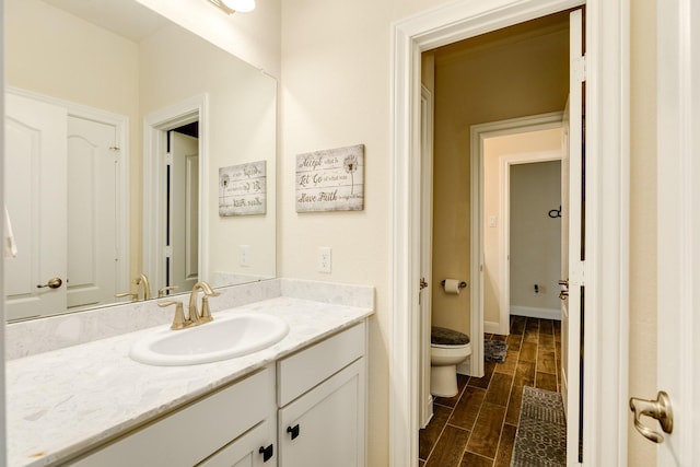 bathroom with hardwood / wood-style flooring, vanity, and toilet